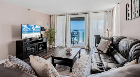 Settle into your living room and watch waves roll in through floor-to-ceiling glass doors opening to your private balcony. Plush seating and modern entertainment await your evening unwind.