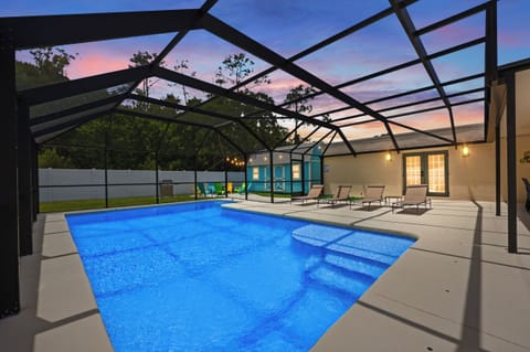 Evening lights turn the heated screened pool into a relaxing retreat.