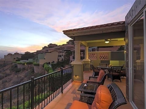 Scenic sunset balcony with lounge seating and covered outdoor dining