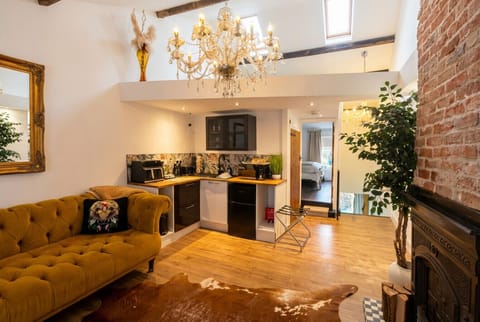 Velvet sofas, a crystal chandelier, exposed beams, and a cast-iron fireplace make this open living space unlike any other.