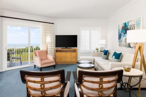 Bright coastal living room with balcony seating and ocean views