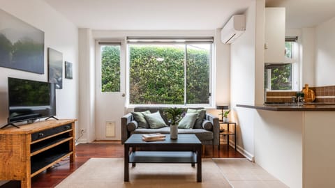 Bright living area with a leafy outlook and comfortable seating.