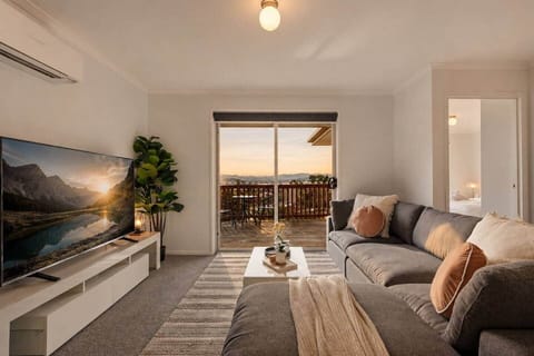 Bright and spacious living room with comfortable seating and stunning mountain views through the balcony doors.