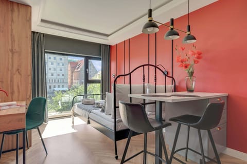 Przestrzeń apartamentu łączy funkcję sypialni, części wypoczynkowej i jadalnianej. Znajduje się w niej wygodne łóżko małżeńskie z hotelową pościelą i kompletem poduszek, telewizor Smart TV z dostępem do kanałów kablowych oraz szafa.