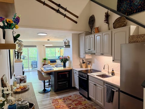 Airy main floor with vaulted ceilings flowing to balcony & river.