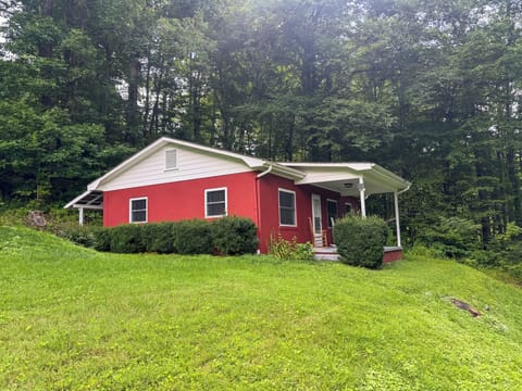 Front of Cottage, featuring a lush green lawn and inviting porch.