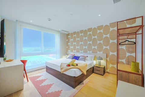 Step into your serene retreat, where warm wood tones and a plush bed invite you to unwind. The textured accent wall and natural light create a calming sanctuary for your perfect getaway.