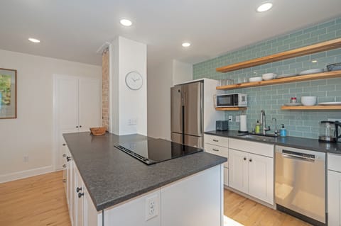 Chef's kitchen with large island, induction cooktop, and dishwasher.