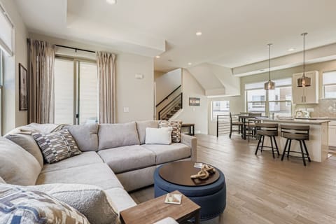 Sink into the plush sectional and let natural light fill your open-concept living space, where vaulted ceilings and modern finishes create an airy retreat perfect for relaxing or gathering with loved ones.