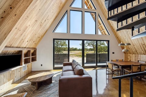 Bathed in the amber glow of golden hour, the cabin’s interior opens onto a sweeping view of Legacy Lake