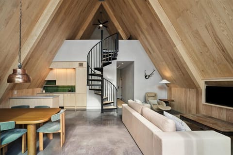 Bathed in the amber glow of golden hour, the cabin’s interior opens onto a sweeping view of Legacy Lake