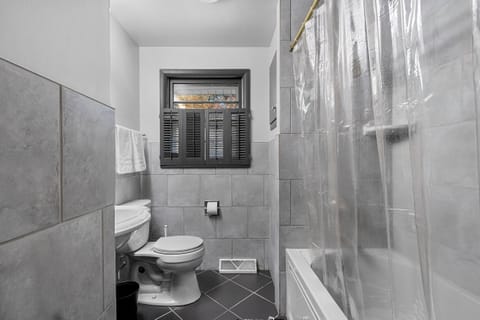 Modern tiled bathroom with tub/shower combo and natural light