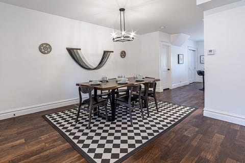 Formal Dining Area: Dine in style in this open-concept dining space situated between the kitchen and living room, complete with a contemporary table setting and chic overhead lighting.