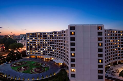 Arrive to a glowing landmark façade at blue-hour twilight.
