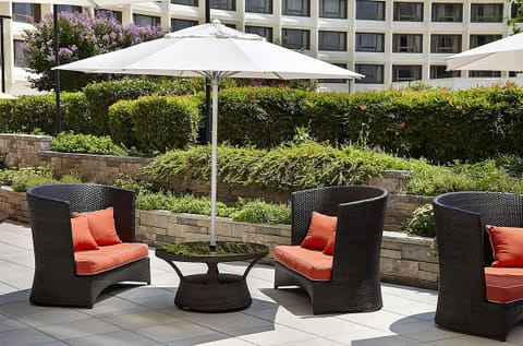Sip cocktails in cushioned shade beside lush garden greenery.