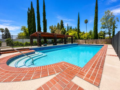 Resort-style pool with shaded pergola and private sunny deck