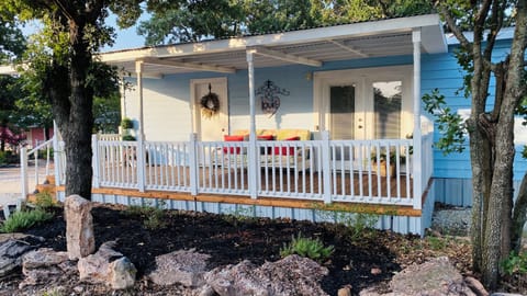 Charming cottage with a covered porch, shaded seating, and inviting curb appeal