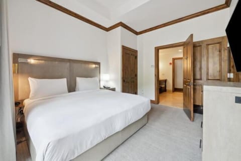 Spacious king bedroom with high ceilings and elegant wood accents