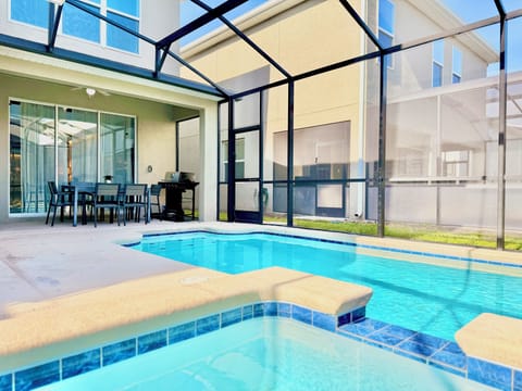 View back toward home, showing pool, spa, covered patio, and outdoor dining.



