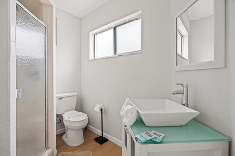 Bright modern bathroom with glass shower and sleek vessel sink