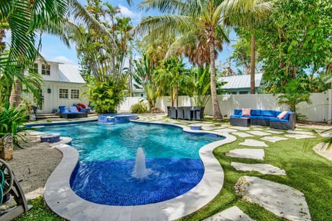 Tropical resort-style pool oasis with lush landscaping and outdoor lounge areas