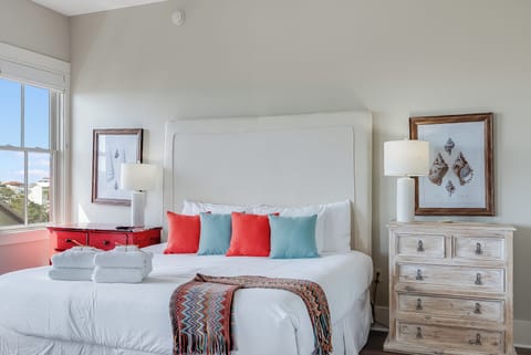Bright coastal bedroom with plush king bed and cheerful decor