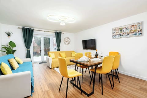 Bright, open-plan living and dining space with comfortable seating, a dining table for group meals, and a welcoming, homely feel.