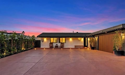 Front exterior of the house showcasing spacious paved driveway. 