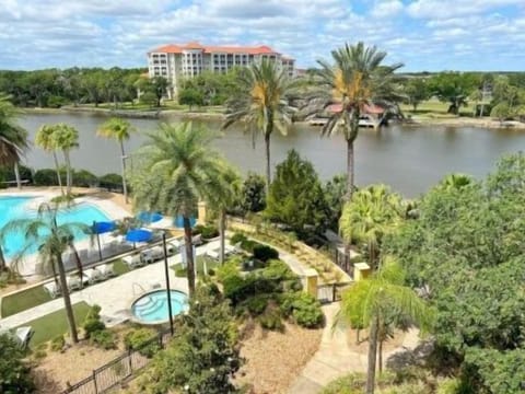 View from the balcony taking in the community pool, lush greenery, and open Intracoastal beyond