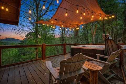 ✨ Soak under the stars in your private hot tub, surrounded by mountain views, string lights, and peaceful forest scenery.