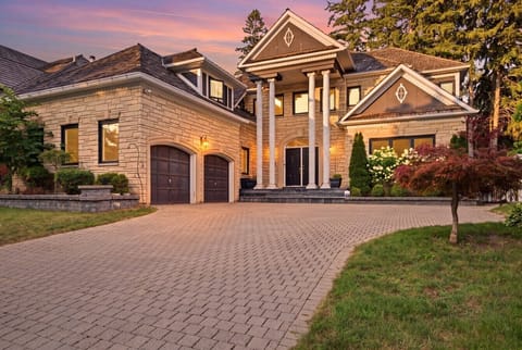 Front Exterior & Driveway at Dusk — stone facade, columned entrance, double garage, showcases the 4-car driveway.