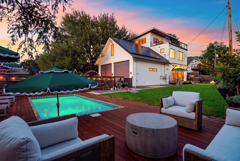 Sunset over the pool, hot tub, and string-lit backyard