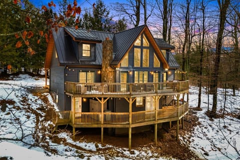 Modern mountain retreat with stunning A-frame architecture, soaring windows, expansive wraparound decks, and peaceful forest views. Cozy up by the fire, soak in the hot tub, and enjoy the perfect blend of comfort and nature.