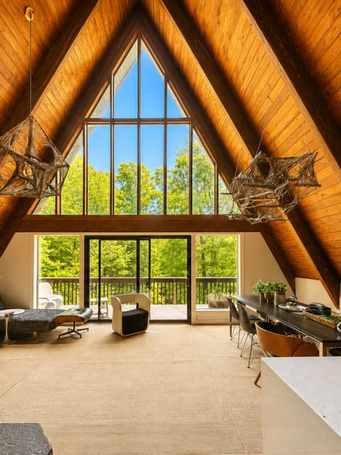Floor-to-ceiling windows frame peaceful treetop views in the heart of this iconic A-frame.