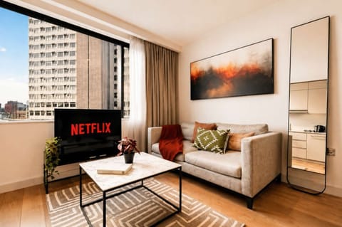 Relax in the bright and welcoming open-plan living area, furnished with comfortable sofa seating and a Smart TV. The space provides an ideal setting for enjoying entertainment or unwinding after discovering Manchester.