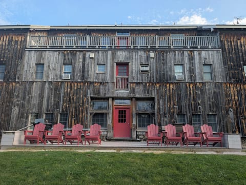 Rustic lodge exterior with Adirondack seating and charming red accents