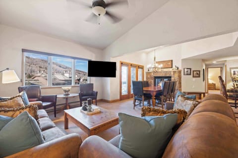 Living room: TV with basic cable, wood-burning fireplace, sofas, leather chairs 