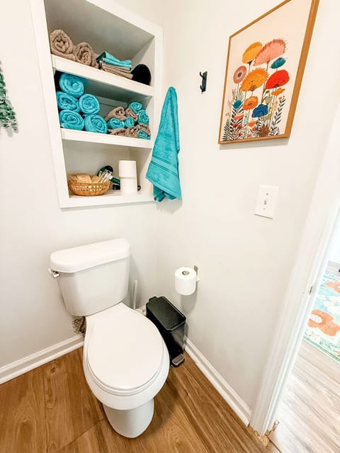 Bright bathroom with stocked towel shelves and cheerful modern decor