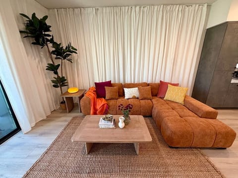 Rust-toned sectional and jute rug set the tone for easy gathering in the main living space.