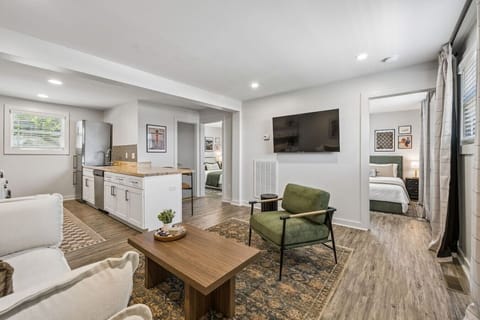 Cozy living room with a Smart TV and comfortable furnishings for you to relax. Open concept area leading into the kitchen, dining high top, and washer/dryer area.