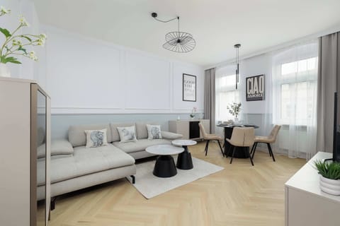 A bright living room with a comfortable sofa, coffee table, and large windows.