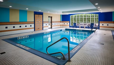 Bright indoor pool with blue-tiled walls and comfortable seating.