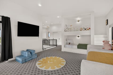 Spacious family bunk room with loft beds, TV, and playful kid-friendly touches