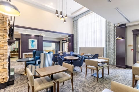 Inviting dining lounge with fireplace, colourful seating, and artwork.