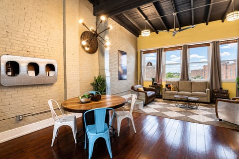 Gather around this rustic round wood table with fun blue and white chairs for a great meal. The open layout makes it easy to chat with friends in the living space.