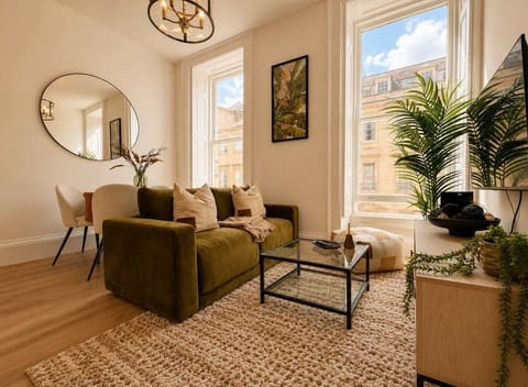 The living room features a cosy sofa and a smart TV for entertainment