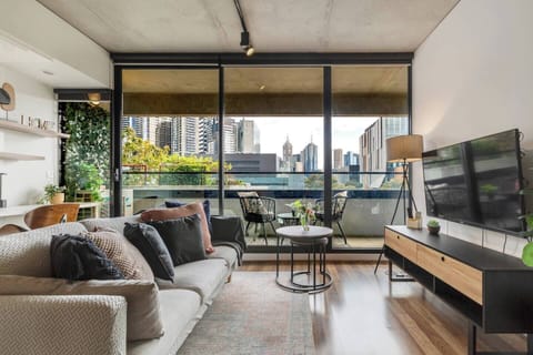 Sink into the comfort of the light-filled living area, where generous windows showcase skyline views and plush seating invites easy relaxation.