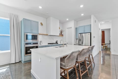 Gather around the island while someone flips pancakes and the coffee goes on. With seating for four and room for helpers, this is where your mornings start slow and your evenings run long, everyone talking over everyone else.