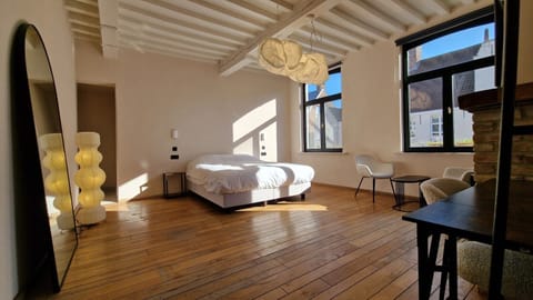 Space and sunlight: the full 33 m² of Room 5, with its arched mirror, sculptural lamps and heritage beams overhead.