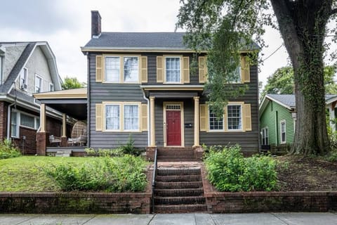 Charming two-story home with red door, covered porch, and classic curb appeal